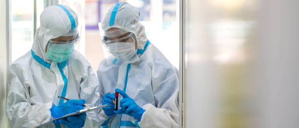 Asian doctor checking coronavirus or covid-19 infected patient in quarantine room stock photo
