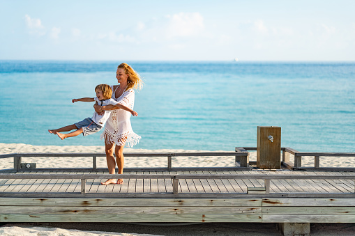 Mom and son is playing at beach pier