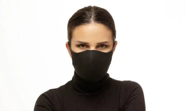 Front view close-up shooting of masked woman looking at camera. protecting herself from virus.
