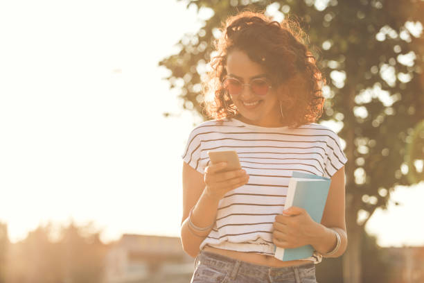 istock Girl smiling while reading text on phone 1216869214