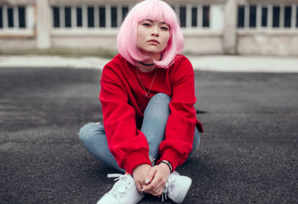 istock Asian hipster sitting on ground on street 1216869492