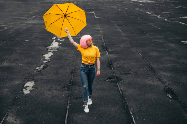 nastoletni influencer z żółtym parasolem chodzącym po ulicy - parasol umbrella asian ethnicity asian culture zdjęcia i obrazy z banku zdjęć