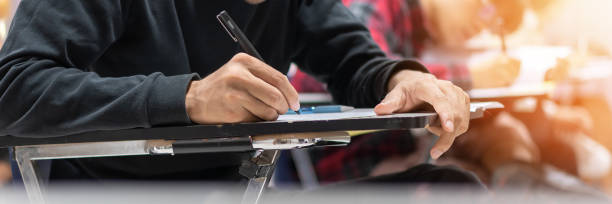istock Exam at school with student's taking educational admission test in class, thinking hard, writing answer in university classroom, education and world literacy day concept 1216869658