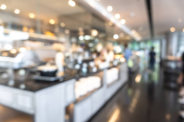 istock Buffet at hotel restaurant interior blur background with blurry open kitchen counter bar of food catering service business with chef staff cooking for breakfast, lunch or dinner meal 1216871521