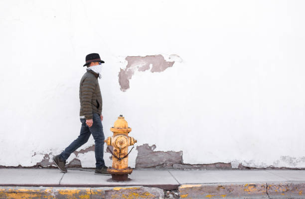 istock Man Walking Down Sidewalk Wearing Bandana Mask 1216871627