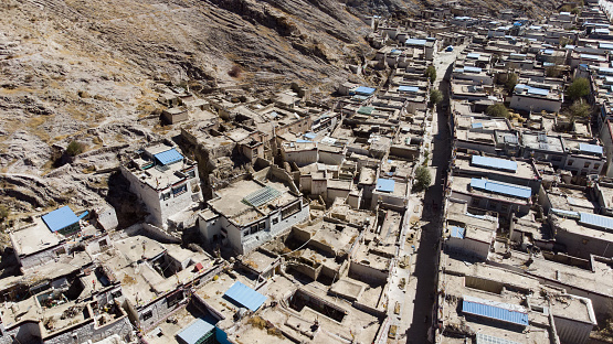 City of Xigaze at Tibet from the sky. A aerial view over a small Tibetan village in the mountain of the Himalayas. Drone view over the roof of Shigatse, Tibet, China. Small houses and narrow roads