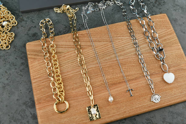 istock Gold and silver handmade chains. on a wooden background. Ornaments from decorative chains. Materials for handmade and hobby. Colorful background of silver and gold chains 1216886936