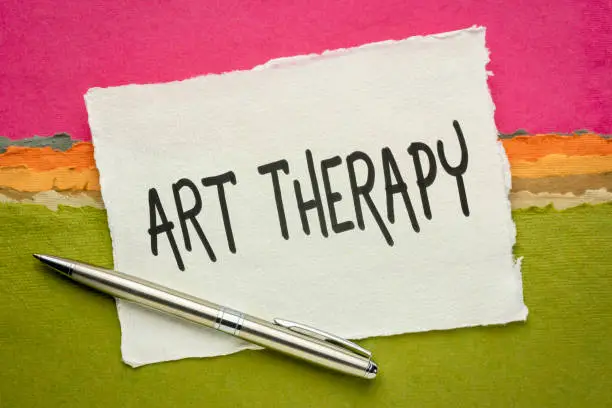 art therapy - handwriting on a handmade khadi paper against colorful abstract landscape, explore emotions, reduce anxiety, increase self-esteem, and resolve other psychological conflicts