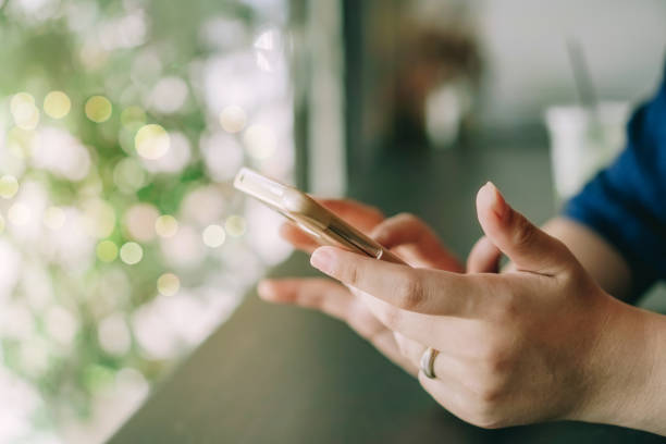 istock Woman hand using smartphone to do work business, social network, communication in public cafe work space area. 1216888972
