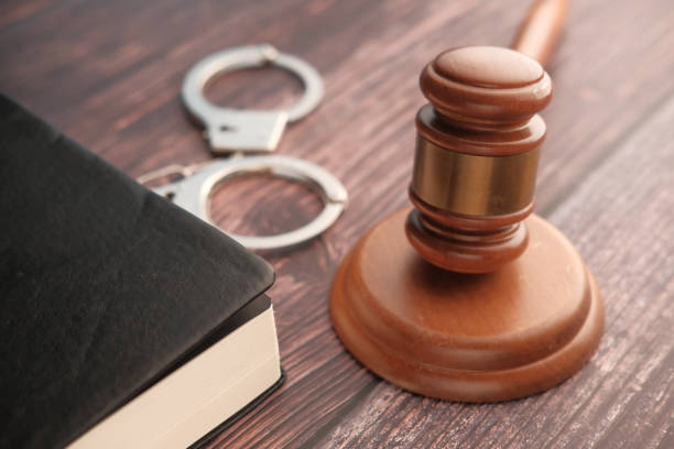istock Close up of gavel, book and handcuff on table 1216890237