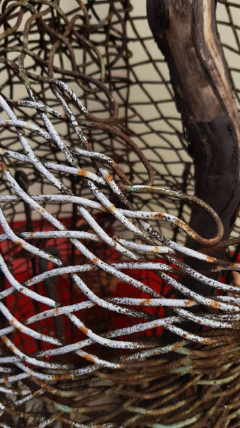 istock Dirty rusty metal wire mesh texture closeup with blurred background. Crumpled metallic netting of tangled chain-link structure. Industrial grunge backdrop. 1216899483