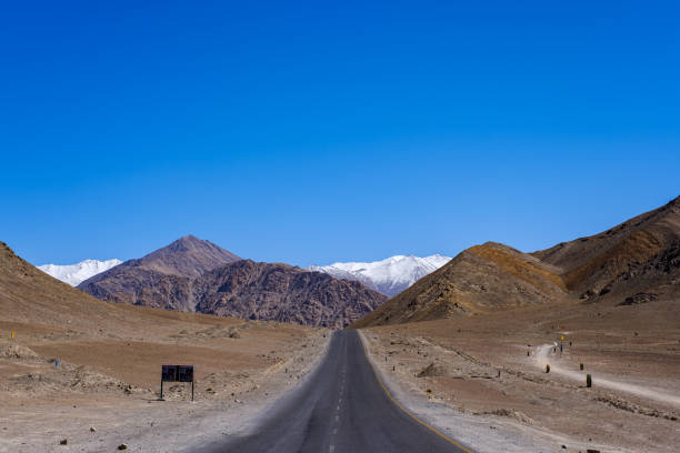 Long straight road to Magnetic Hill in Leh, Ladakh The long straight road to Magnetic Hill a famous place located near Leh, Ladakh, Jammu and Kashmir, India. leh district stock pictures, royalty-free photos & images