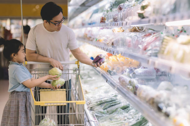 istock an asian chinese male buying fruit selecting them at refrigerated section vegetable store together with his daughter in supermarket 1216901445