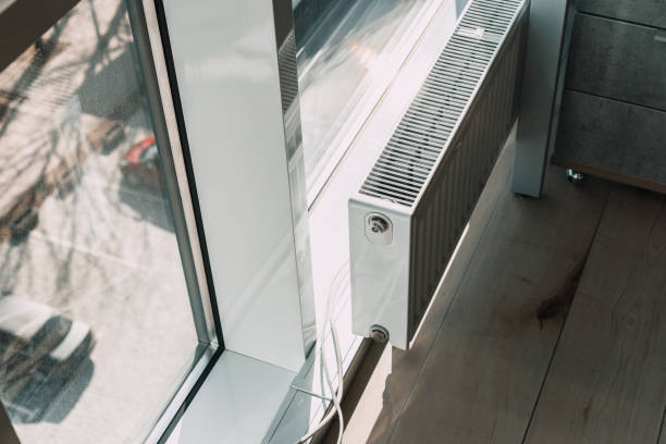 istock modern white radiator battery in the office near the window. 1216901534