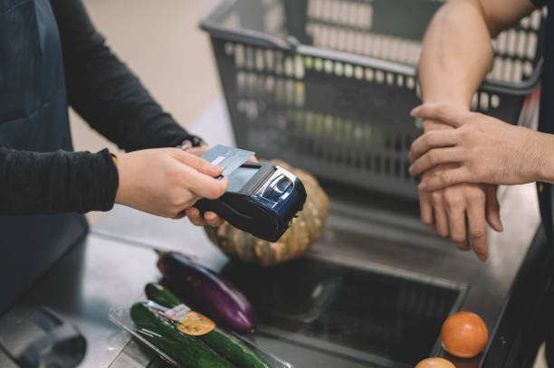 azjatycka chińska kobieta sprzedawca detaliczny kasjer skanowanie karty kredytowej od klienta podczas kasy w kasie za pomocą skanera karty kredytowej - cash register paying checkout counter cashier zdjęcia i obrazy z banku zdjęć