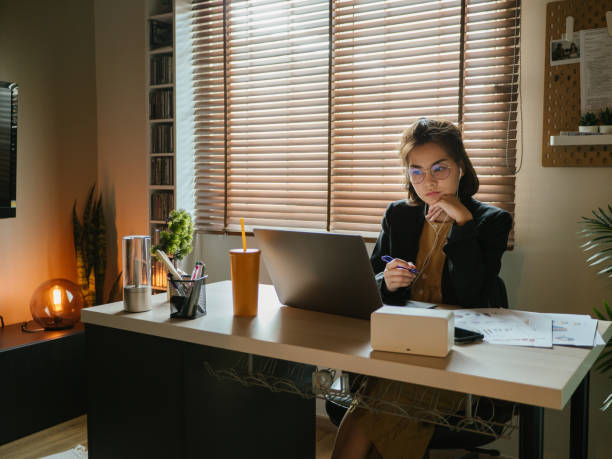 istock Asian woman using laptop during conference call at home. 1216902327