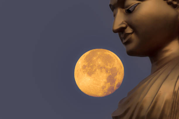 Face Golden Buddha statue at night with a full moo
