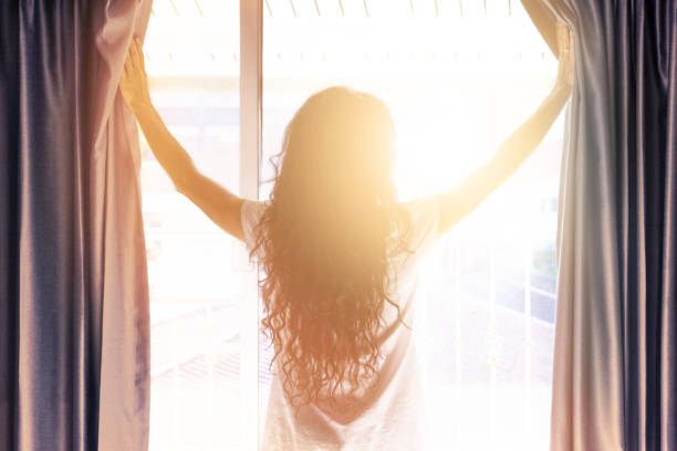 istock Woman opens the curtains in the morning 1216905951