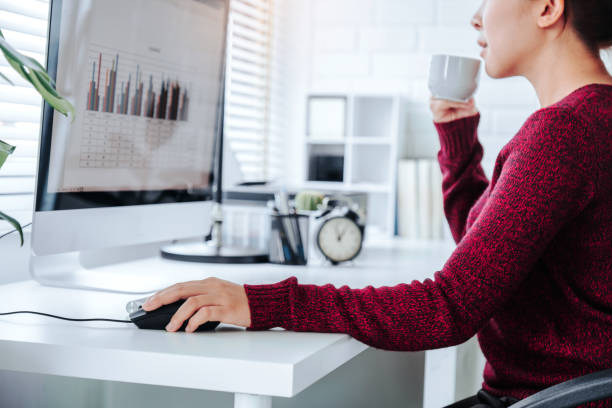 istock Asian woman working from home using computer and drinking coffee in her bedroom document finance and conference online meeting for new projects 1216908220