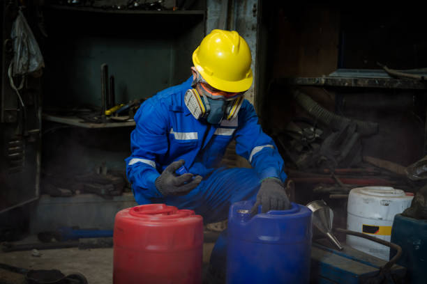 a worker industry wearing safety uniform ,black gloves and gas mask under checking chemical tank in industry factory work - half tank imagens e fotografias de stock
