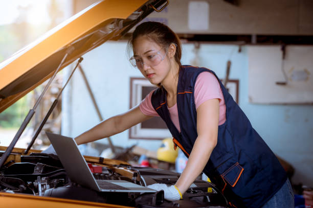 オープンフードビューで車を修理し、車のガレージサービスで補充またはクリーンのためのレベルモーターオイルをチェックする女性の車のメカニック - vehicle breakdown hood car oil change ストックフォトと画像