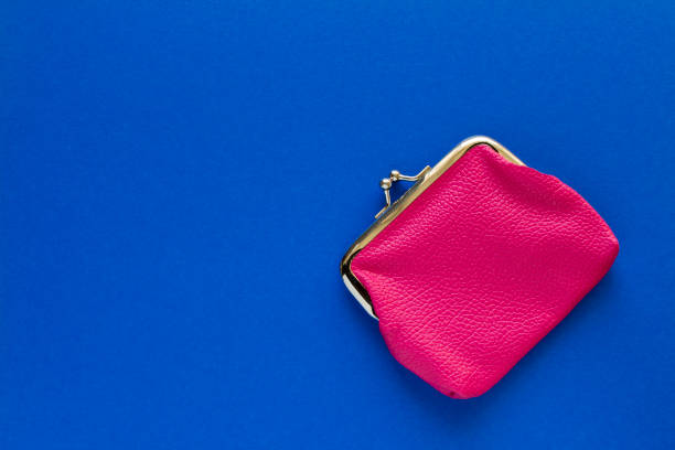 istock Fashionable pink wallet on a blue background. Close up. 1216910205