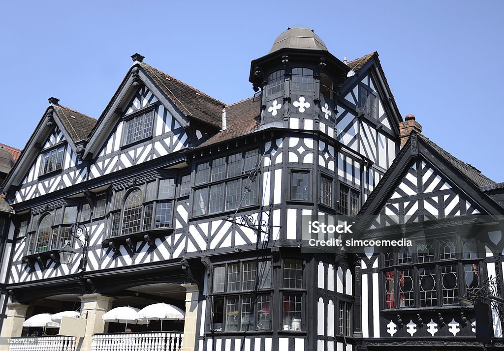 Classic Architecture Styles in Chester City Centre Classic black and white style buildings on Eastgate Street in Chester. The sun is shining on the traditional black and white woodwork of the building's facade. Chester - England Stock Photo