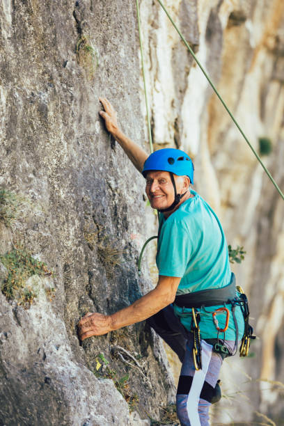 istock Senior man with a rope climbing on the rock. 1216912838
