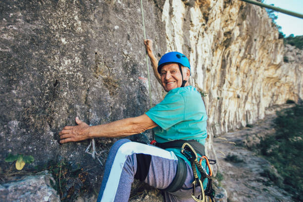 istock Senior man with a rope climbing on the rock. 1216913609