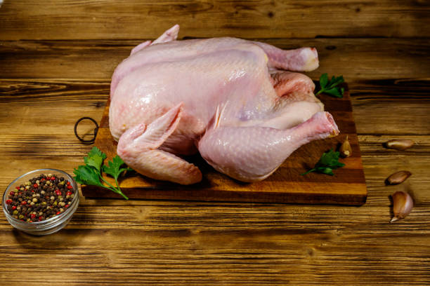 istock Raw whole chicken with spices on a wooden table 1216914005