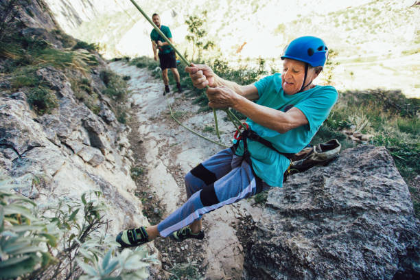 istock Senior man with a rope climbing on the rock. 1216914160