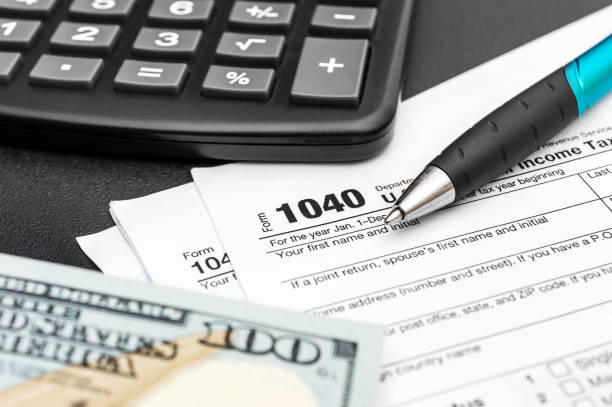 Tax forms with money, calculator and pen on black. Business concept. Tax forms with money, calculator and pen on black. Business concept. tax season photos stock pictures, royalty-free photos & images