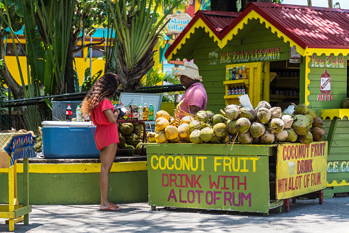 Ocho Rios, Jamaica - April 22, 2019: Ice Cold Coconut Fruit Drink with Rum stall/corner shop in rasta colors at the Ocho Rios Cruise Ship Port in the streets of Ocho Rios, Jamaica.