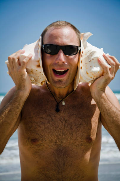 istock Man listening to Sea Shells 121691527