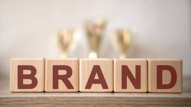 istock BRAND text on wooden cubes with winning cups 1216915306