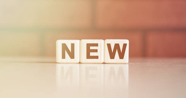 istock NEW - concept. Text on wooden cubes with bright light 1216915322