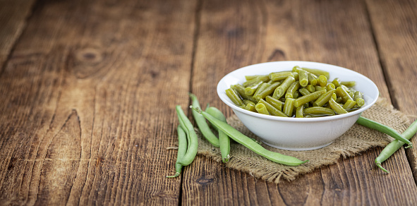 Preserved Green Beans as detailed close-up shot  (selective focus) on vintage background