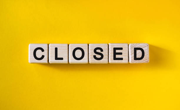 istock Inscription black dough CLOSED on a yellow monochrome background 1216915610