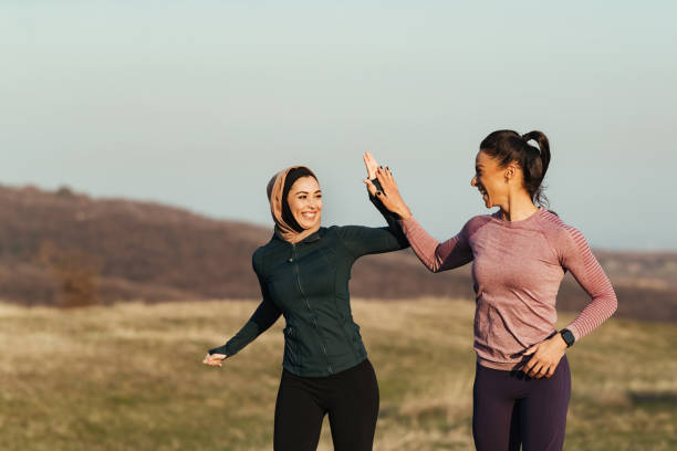istock Happy sportswomen having fun while running and giving high-five in nature. 1216915765