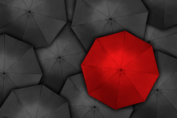 istock Red umbrella over many dark ones 1216918000