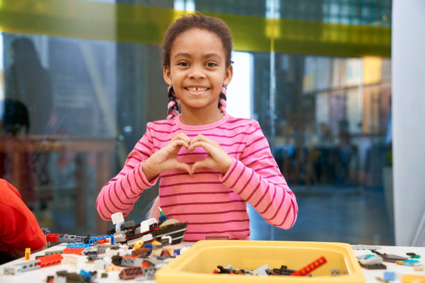 afrykańska dziewczyna pokazująca gest serca. - child building activity construction engineer zdjęcia i obrazy z banku zdjęć