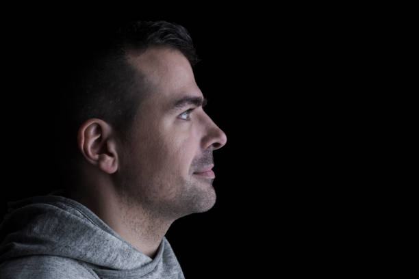 istock Side studio portrait of a serious man looking sideways. Isolated on black background 1216922611