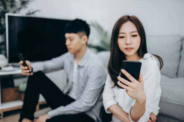 istock Young Asian couple using smartphone for entertainment during self isolation in Covid-19 health crisis 1216924519