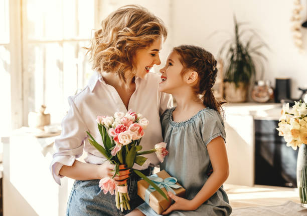 heureuse fête des mères! la fille d’enfant donne des fleurs pour la mère en vacances - small bouquet photos et images de collection