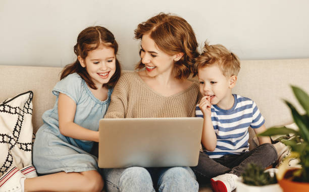 istock Happy mother with kids using laptop at home 1216925348
