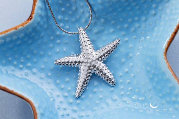 istock Starfish shape silver pendant necklace on blue background 1216928515