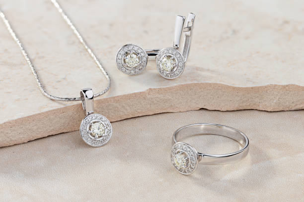 Elegant jewelry set of white gold ring, necklace and earrings with diamonds Elegant jewelry set of white gold ring, necklace and earrings with diamonds. Silver jewellery set with gemstones. Product still life concept earring stock pictures, royalty-free photos & images