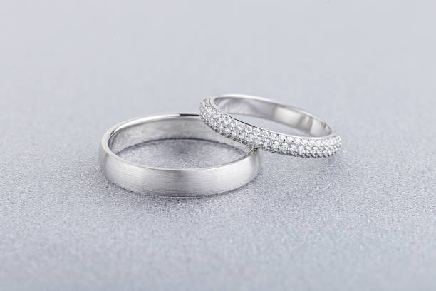 Pair of silver wedding rings on gray background stock photo