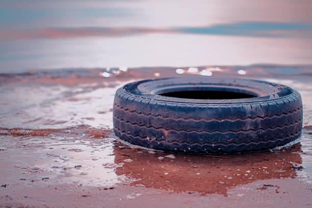 istock Black tires on the beach 1216929817