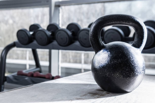 istock Kettlebell and dumbbell in the background black light background 1216930898